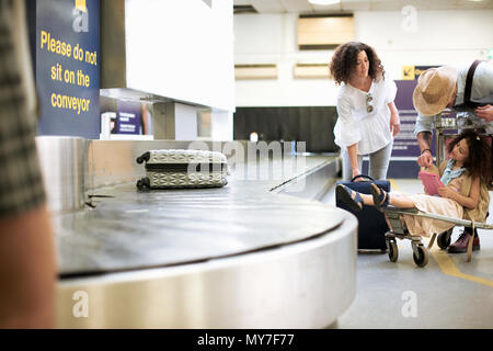 La collecte de la famille valise de carousel in airport Banque D'Images