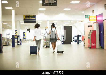 Les amis avec les valises dans l'aéroport Banque D'Images