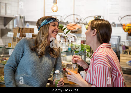 Deux jeunes amies rient ensemble dans cafe Banque D'Images