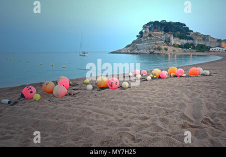 Les bouées orange et rose sur la plage de sable de Tossa de Mar, dans l'arrière-plan, la vieille ville de Vila Vella de Tossa de Mar, Costa Brava Banque D'Images
