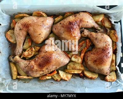 Des cuisses de poulet épicé grillé avec des pommes de terre sur un plat à four. L'alimentation biologique. Banque D'Images