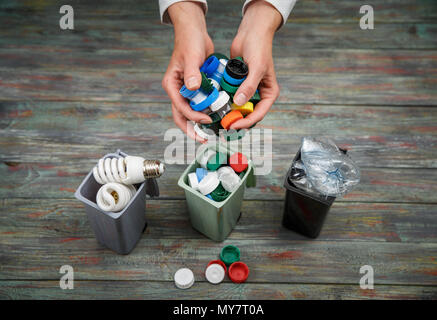 Concept de l'écologie, beaucoup d'objets recyclables dans des conteneurs sur le fond en bois. Banque D'Images