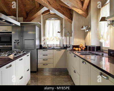 Cuisine moderne dans le grenier de l'intérieur chambre avec plafond en bois et d'île de cuisine Banque D'Images