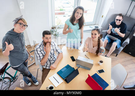 Les jeunes gens joyeux showing Thumbs up pour co-working Banque D'Images