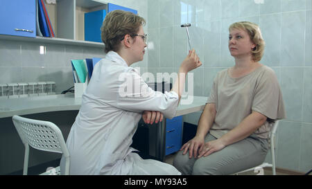 L'exécution de tests neurologiques neurologue femelle sur une patiente dans un bureau Banque D'Images