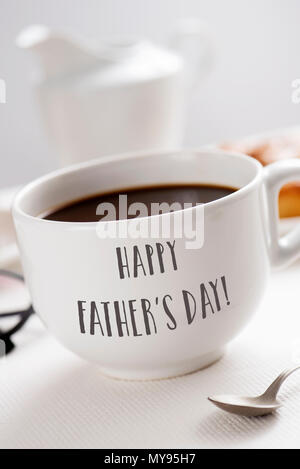 Libre d'une tasse en céramique blanche avec du café, avec le texte happy fathers day écrit en C, à un set de table pour le petit déjeuner Banque D'Images