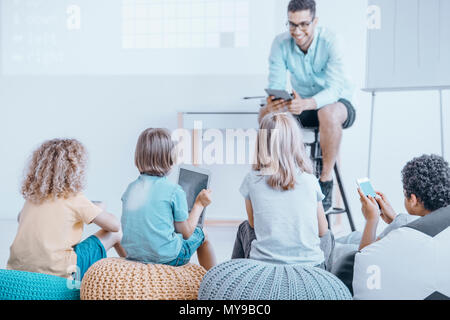 Les leçons dans une classe peu commune à l'aide d'un smartphone et tablette. Concept d'enseignement modernes Banque D'Images