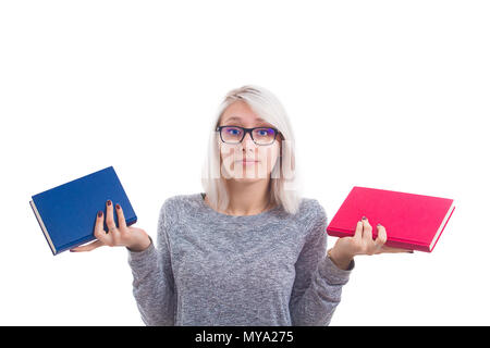 Fille étudiante confus de choisir entre deux livres, rouge et bleu, à droite ou à gauche. Décision difficile, l'éducation concept, faire le bon choix. Blonde Banque D'Images