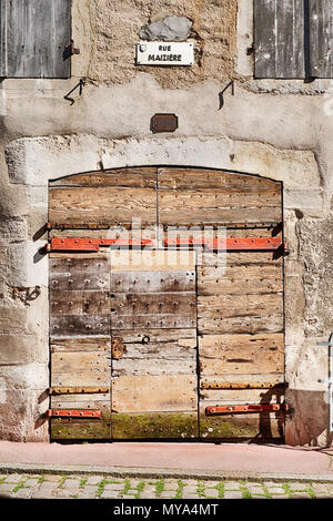 Un ancien garage porte faite de plusieurs morceaux de bois a subi des siècles d'intempéries sur Rue Maziere dans la ville de Beaune en Bourgogne, en France. Banque D'Images