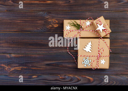Trois boîtes de fête en papier décoré avec des flocons de craf et star sur table en bois. Vue d'en haut. Banque D'Images