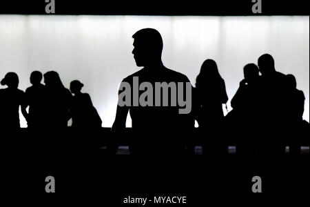 Silhouette de jeune homme seul et une foule de gens qui marchent derrière lui trouble dans la nuit Banque D'Images
