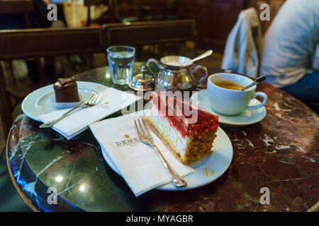 Vienne, Autriche - 22 octobre 2017 : sur la table de la célèbre confiserie Café Demel il y a cherry cake, mini gâteau Sacher et tasse à café avec es Banque D'Images