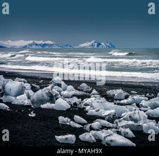 La glace sur une plage de sable noir, Breidamerkurfjara beach, calotte de glace, l'Islande Vatnajokull. Grande glace de mandrins mettent bas au large du Breidamerkurjokull et Banque D'Images