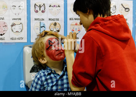 Un petit garçon (4 ans) ayant son visage peint rouge lumineux Banque D'Images