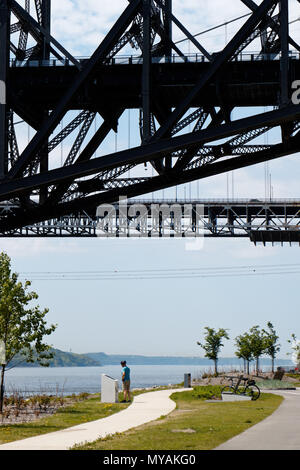 Un cycliste de détente sur la Promenade Samuel de Champlain cbike chemin dans la ville de Québec, Canada avec le Pont du Québec Frais généraux Banque D'Images