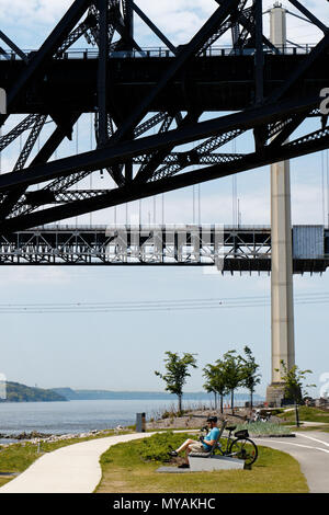 Un cycliste de détente sur la Promenade Samuel de Champlain cbike chemin dans la ville de Québec, Canada avec le Pont du Québec Frais généraux Banque D'Images