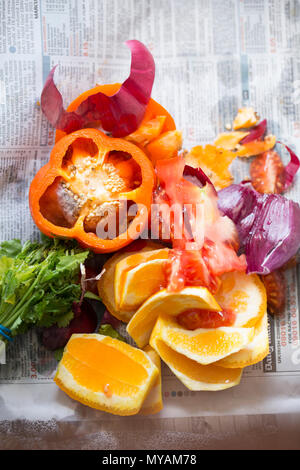 Une sélection de pelures de fruits et légumes prêts à être emballés dans du papier journal et placés dans un bac de recyclage. UK Banque D'Images