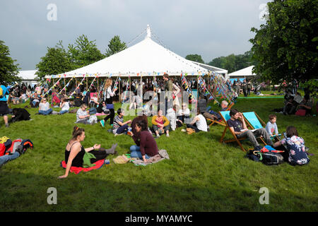 Les gens assis relaxant et allongé sur le sol à l'extérieur par la lecture sur le chapiteau Hay Festival site dans sunshine 2018 Hay-on-Wye au Pays de Galles UK KATHY DEWITT Banque D'Images