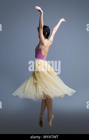 Ballerine danse en studio sur un fond gris Banque D'Images