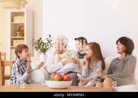 Des enfants heureux de passer du temps avec les grands-parents dans la salle de séjour Banque D'Images