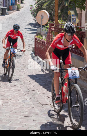 Les cyclistes masculins turc rivaliser sur la scène internationale, une course de VTT dans les rues du village grec de Molyvos sur l'île de Lesbos Banque D'Images