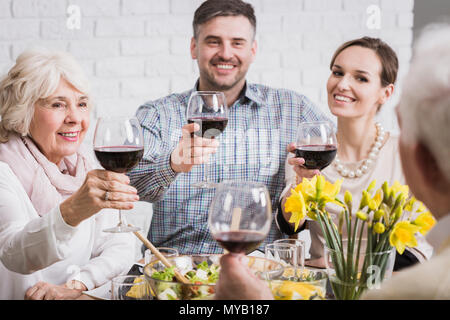 Potable de la famille toast pour un homme âgé, holding glasses with red wine, smiling Banque D'Images