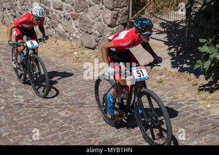 Les cyclistes masculins turc rivaliser sur la scène internationale, une course de VTT dans les rues du village grec de Molyvos sur l'île de Lesbos Banque D'Images