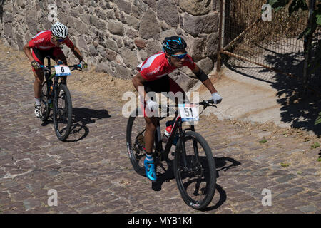 Les cyclistes masculins turc rivaliser sur la scène internationale, une course de VTT dans les rues du village grec de Molyvos sur l'île de Lesbos Banque D'Images