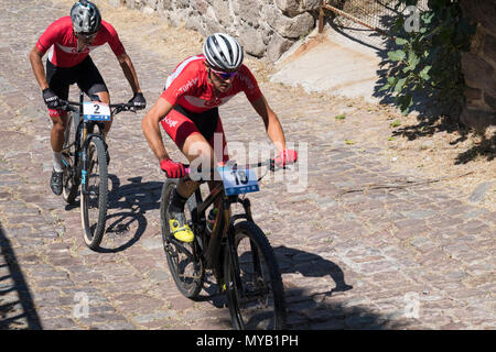 Les cyclistes masculins turc rivaliser sur la scène internationale, une course de VTT dans les rues du village grec de Molyvos sur l'île de Lesbos Banque D'Images