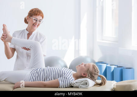 Physiothérapeute donnant un massage des jambes pour petite fille
