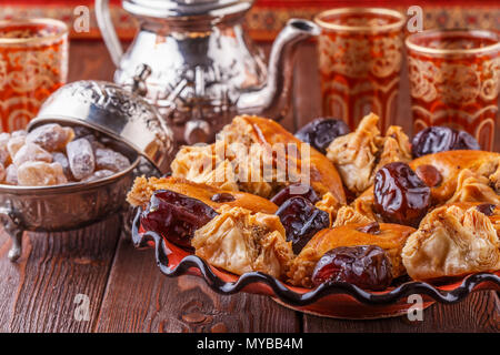 Thé à la menthe marocain traditionnel dans les verres avec des bonbons, selective focus. Banque D'Images