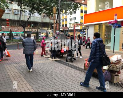 Rue de Hong Kong avec quelques personnes et de l'alimentation de rue traditionnels pushcart. La cuisine en plein air châtaignes grillées, œufs de caille, de la patate douce. Banque D'Images