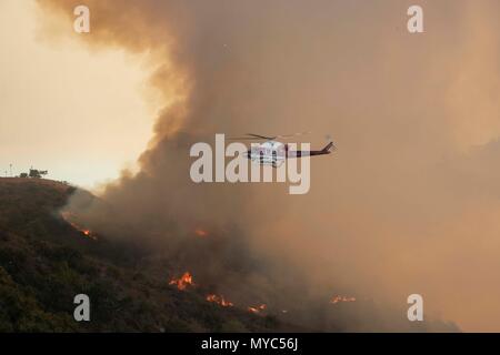 OCFA fire flies hélicoptère à travers la fumée pour aider à combattre l'Aliso Viejo un feu de broussailles qui a commencé le 2 juin, 2018. Banque D'Images