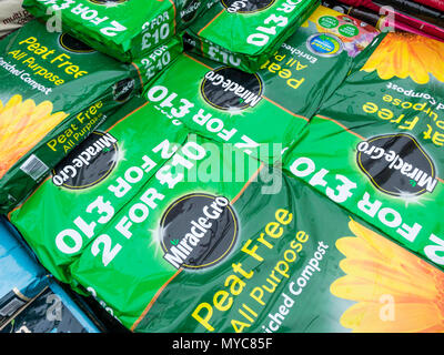 Une pile de sacs de tourbe Engrais Miracle-Gro tout usage de compost enrichi dans un centre de jardinage Banque D'Images