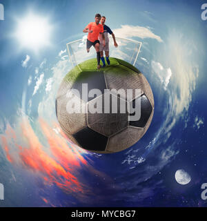 Les joueurs de football dans un ballon de foot planète Banque D'Images
