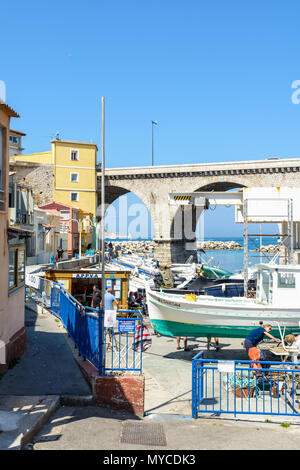 Le petit port de pêche du Vallon des Auffes à Marseille par un matin ensoleillé avec des bateaux et à l'arsenal et le pont-route de la Corniche Kennedy. Banque D'Images