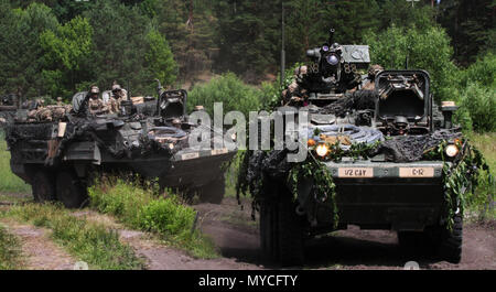 Des soldats américains au combat Group Pologne conduire un véhicule blindé intérimaire de l'armée américaine Stryker autour d'un danger de l'eau à la zone d'entraînement Bemowo Piskie le 5 juin 2018 dans le cadre de leur participation à la grève de sabre 18. Grève 18 Sabre est la huitième édition de l'armée américaine de longue date par l'Europe de la formation coopérative exercice visant à accroître l'interopérabilité entre les alliés et les partenaires régionaux. (Michigan Army National Guard photo de la CPS. Robert Douglas/publié.) Banque D'Images