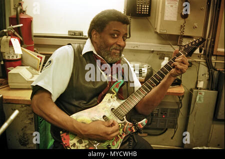 Un nouveau yoyk city Subway train ticket sales officer, joue de la guitare au travail dans son émission de billet stand. Manhattan, New York City, USA, Banque D'Images