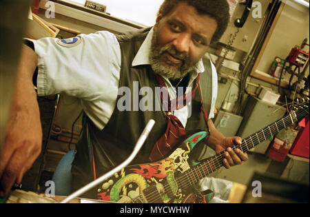 Un nouveau yoyk city Subway train ticket sales officer, joue de la guitare au travail dans son émission de billet stand. Manhattan, New York City, USA, Banque D'Images