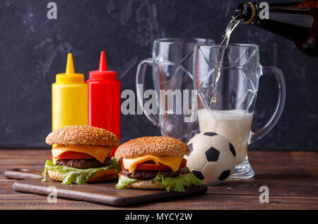 Image de deux hamburgers, lunettes, ballon de soccer, ketchup Banque D'Images