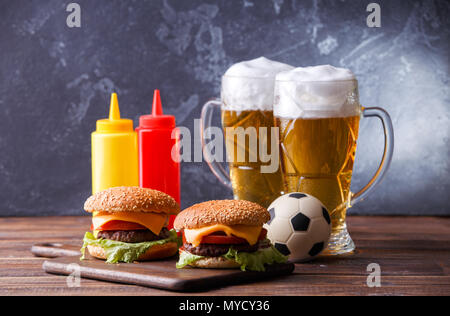 Image de deux hamburgers, lunettes, ballon de soccer, ketchup Banque D'Images