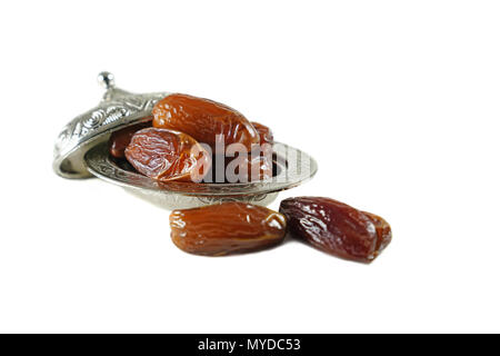 Dates de fruits frais dans un bol en métal argenté sur fond blanc isolé Banque D'Images