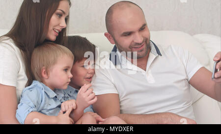 Famille heureuse en regardant leurs photos sur le téléphone Banque D'Images