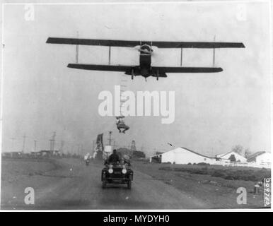 Freddie sans peur, un cascadeur d'Hollywood, accroché à une échelle de corde suspendue à partir d'un avion piloté par H Maltrup, sur le point de tomber dans l'automobile automobile montré ci-dessous- Banque D'Images