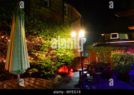 Le jardin illuminé au Village Inn, vieux village de Shanklin, sur l'île de Wight, ressemble enchanteresse la nuit après la pluie. Banque D'Images