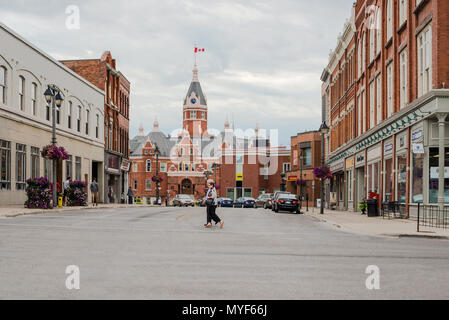 Stratford, Canada - le 8 août 2015 : Les gens de traverser la rue et l'hôtel de ville dans la ville de Stratford en Ontario, à l'arrière-plan Banque D'Images