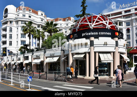 Cannes, France - 11 mai 2018 : Boulevard de la Croisette qui contient des boutiques haut de gamme telles que Rolex, C Gaucherand et une annonce pour le Festival du Film. Banque D'Images