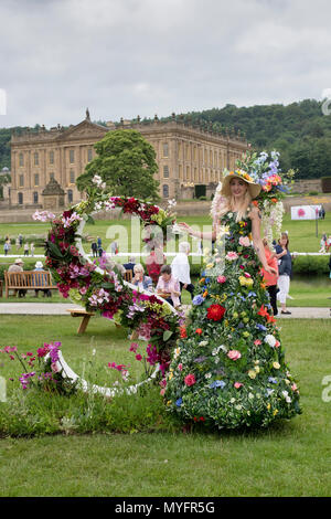 Femme sur pilotis portant un costume floral à Chatsworth RHS Flower Show 2018. Chatsworth, Bakewell, Derbyshire, Royaume-Uni Banque D'Images