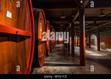 Une rangée de tonneaux de vin et fûts stockés dans un tunnel souterrain à ambiance contrôlée. Banque D'Images