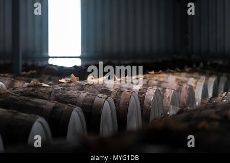 Une énorme collection de vin de barils empilés et stockés dans un hangar de l'âge et de maturité. Banque D'Images